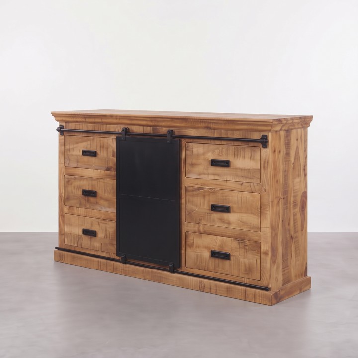 Een dressoir mangohout 160cm (Forge) op een lichte ondergrond tegen een witte wand, voorzien van zes lades met zwarte handgrepen en een centrale zwarte schuifdeur op een metalen rail.