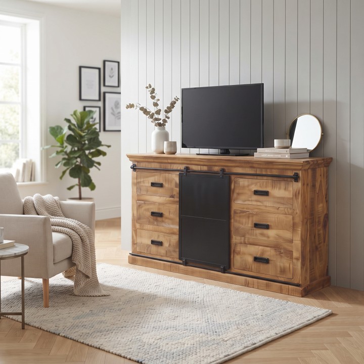 Een licht interieur met visgraatvloer en houten lambrisering, waarop een dressoir mangohout 160cm (Forge) dient als televisiemeubel met een televisie erop.