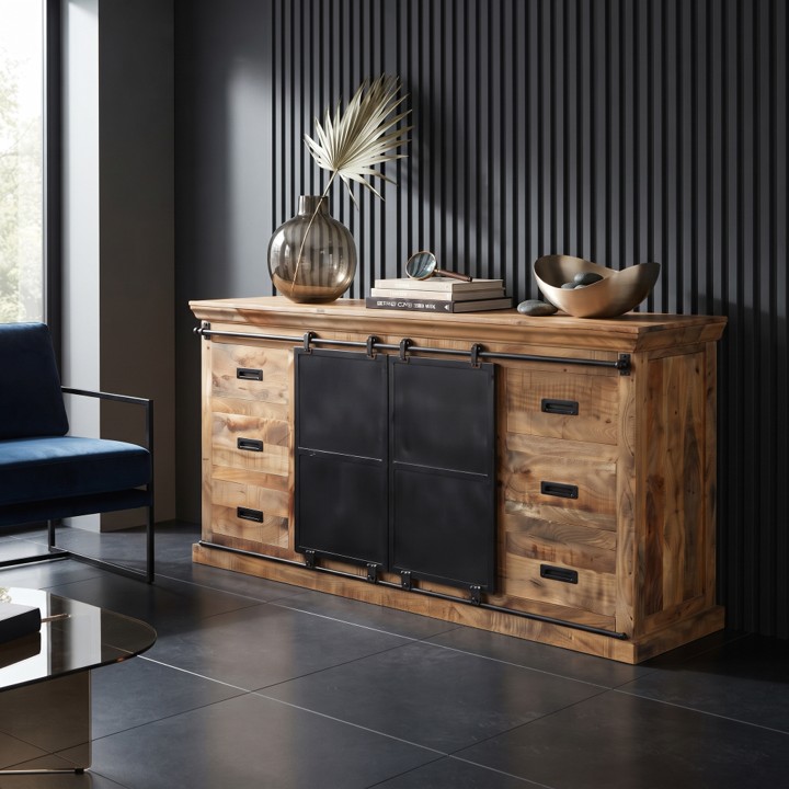 Een sfeervolle, industriële ruimte met een donkere lambrisering en plavuizen, waarin een dressoir mangohout 180cm (Forge) staat met stijlvolle accessoires en een blauwe fauteuil.