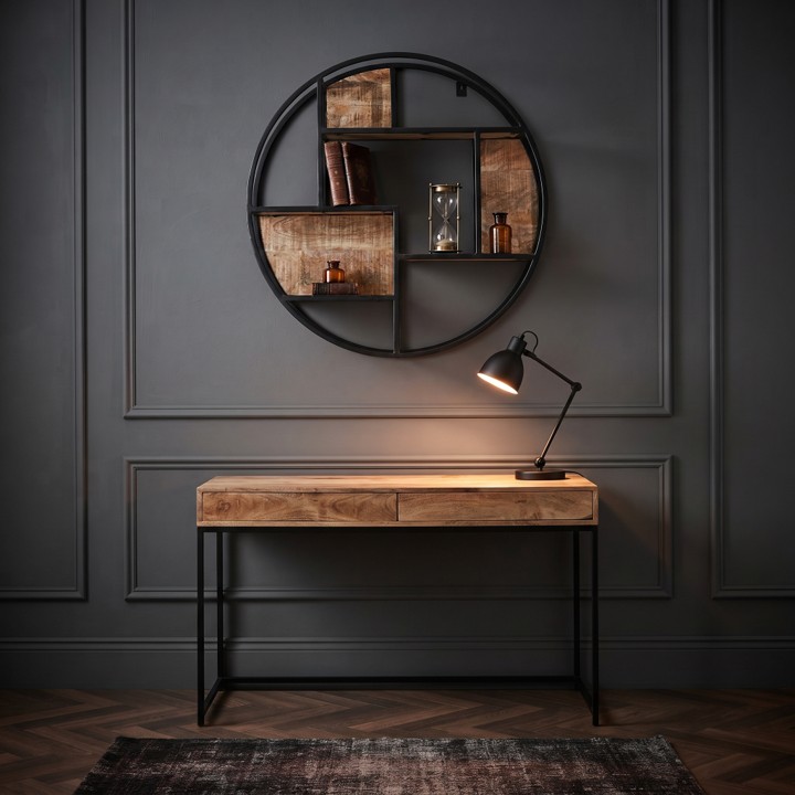 Wandrek rond mangohout 80cm van 80 cm opgehangen aan een donkere muur boven een houten bureau met een zwarte tafellamp.
