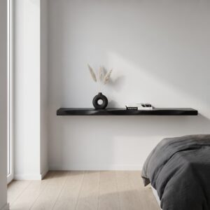 Minimalistische styling van een 200cm zwevende wandplank van zwart mangohout boven een bed.